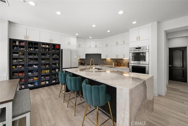1941 Devaul Ranch Dr, San Luis Obispo, CA 93405 - kitchen with double oven, freestanding refrigerator, light wood-style flooring, white cabinets, and recessed lighting