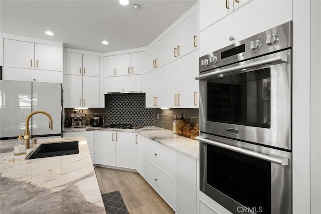 1941 Devaul Ranch Dr, San Luis Obispo, CA 93405 - kitchen featuring double oven, freestanding refrigerator, a sink, white cabinetry, and tasteful backsplash