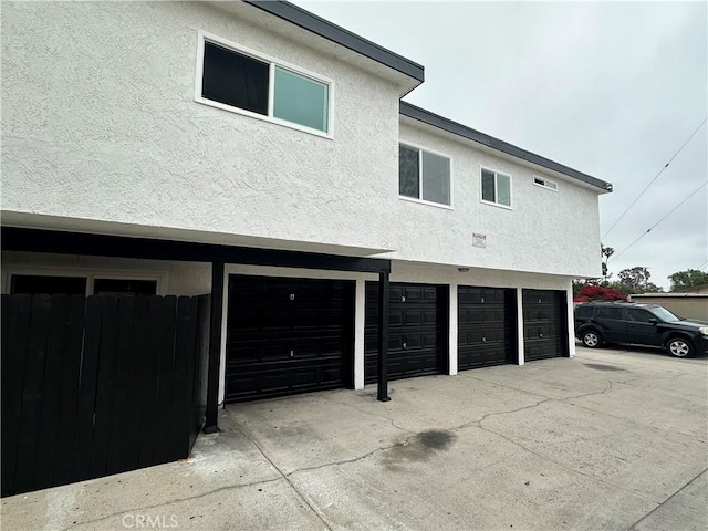 17372 Dairyview Cir, Huntington Beach, CA 92647 - rear view of house with stucco siding, an attached garage, and driveway