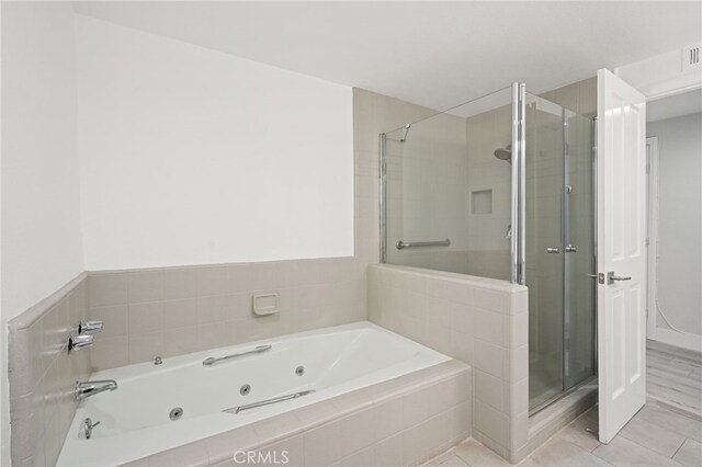 19029 Nordhoff St Unit 103, Northridge, CA 91324 - full bath featuring a stall shower, a jetted tub, and tile patterned flooring