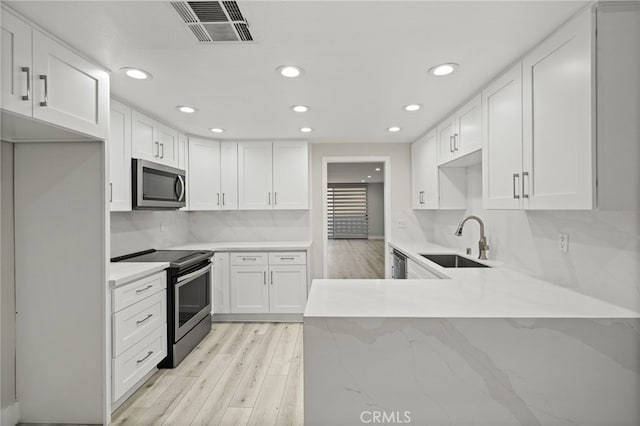19029 Nordhoff St Unit 103, Northridge, CA 91324 - kitchen featuring appliances with stainless steel finishes, a sink, light wood-style floors, recessed lighting, and a peninsula