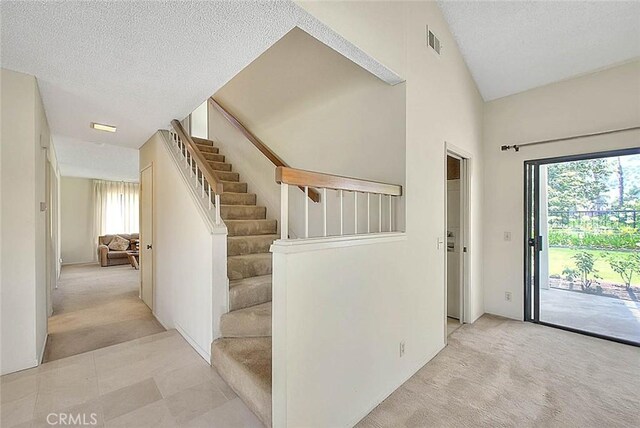 6237 Birdie Dr, La Verne, CA 91750 - stairs featuring carpet, healthy amount of natural light, a textured ceiling, and vaulted ceiling