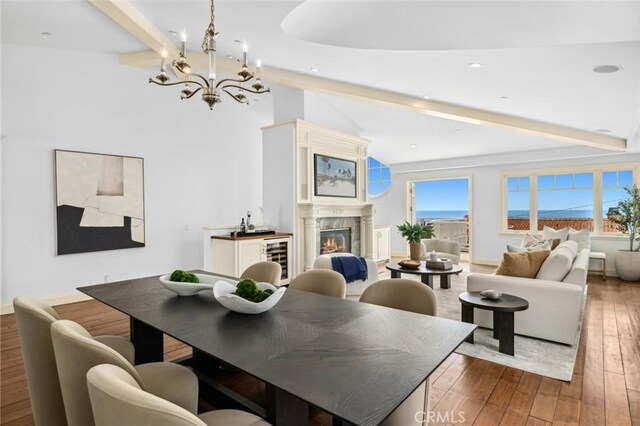 111 Brooks, Laguna Beach, CA 92651 - dining room with a chandelier, hardwood / wood-style floors, a warm lit fireplace, wine cooler, and recessed lighting