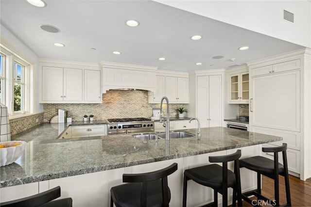 111 Brooks, Laguna Beach, CA 92651 - kitchen with high end range, a sink, dark stone counters, backsplash, and recessed lighting