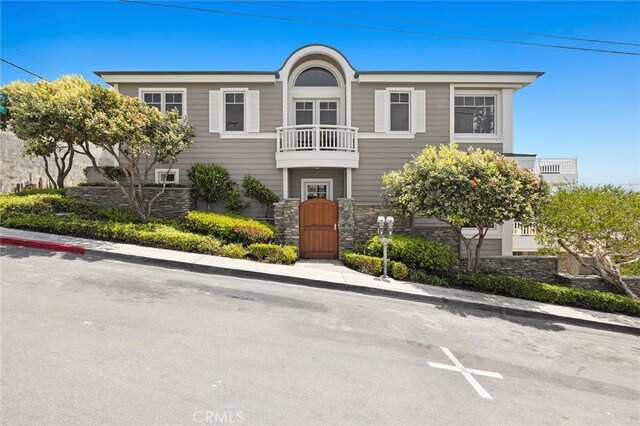111 Brooks, Laguna Beach, CA 92651 - view of front facade with stone siding, a balcony, and a gate