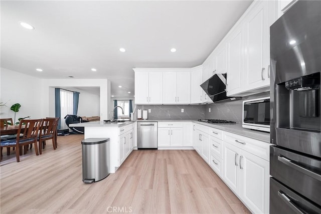 7358 Freedom Pl, Rancho Cucamonga, CA 91730 - kitchen with appliances with stainless steel finishes, a peninsula, recessed lighting, backsplash, and light wood finished floors