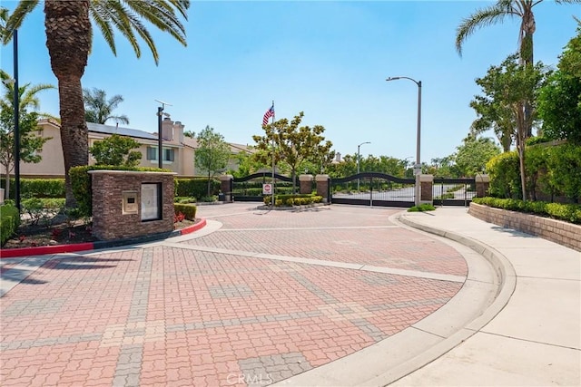 7358 Freedom Pl, Rancho Cucamonga, CA 91730 - view of decorative road featuring curbs, a gate, street lighting, a gated entry, and sidewalks