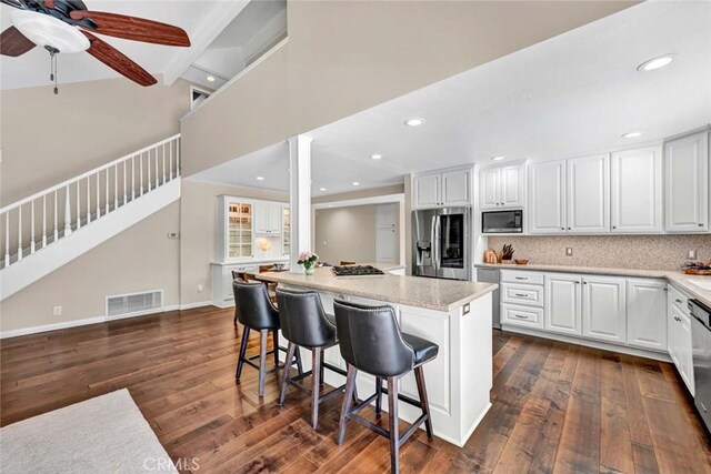 14652 Danborough Rd, Tustin, CA 92780 - kitchen with stainless steel appliances, a ceiling fan, dark wood finished floors, a kitchen breakfast bar, and recessed lighting