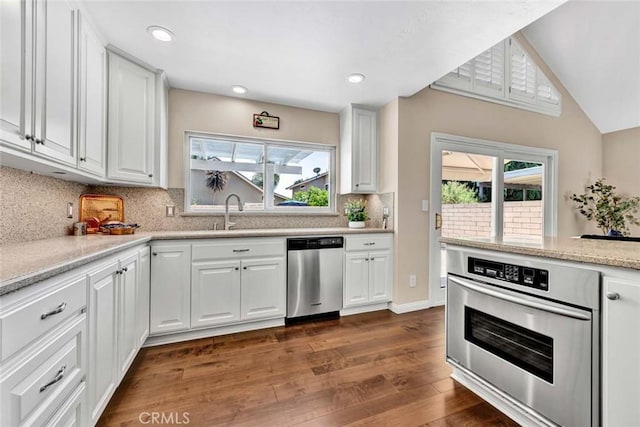 14652 Danborough Rd, Tustin, CA 92780 - kitchen featuring appliances with stainless steel finishes, dark wood finished floors, plenty of natural light, white cabinets, and vaulted ceiling