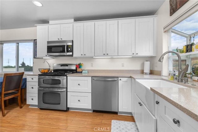 448 Radcliff St, Morro Bay, CA 93442 - kitchen featuring stainless steel appliances, white cabinets, light wood finished floors, recessed lighting, and a sink