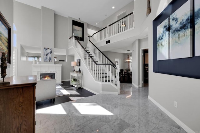 9552 Babauta Rd, San Diego, CA 92129 - foyer entrance featuring a high ceiling, a fireplace, a chandelier, stairs, and recessed lighting