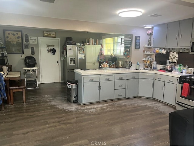 8943 Delano Dr, Riverside, CA 92503 - kitchen with a peninsula, stainless steel fridge, dark wood-style floors, light countertops, and gas range