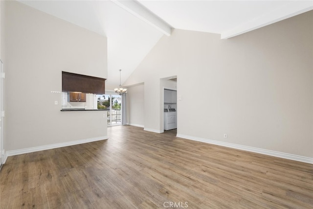 2925 E Spaulding St Unit 304, Long Beach, CA 90804 - unfurnished living room with a chandelier, washer and dryer, beamed ceiling, wood finished floors, and high vaulted ceiling