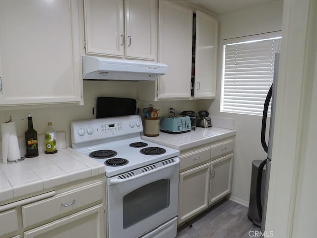 5744 E Creekside Ave Unit 10, Orange, CA 92869 - kitchen featuring under cabinet range hood, white range with electric cooktop, white cabinets, tile counters, and wood finished floors