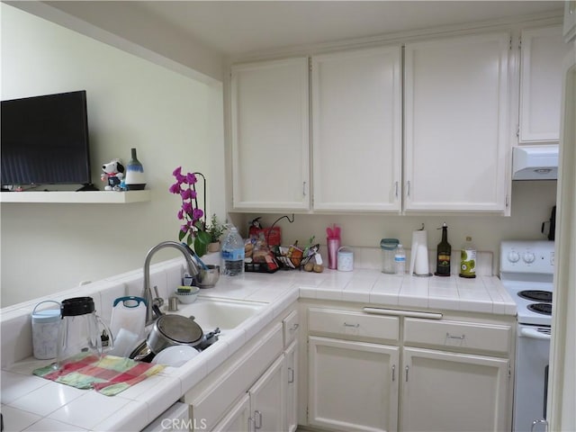 5744 E Creekside Ave Unit 10, Orange, CA 92869 - kitchen with electric range, under cabinet range hood, white cabinets, a sink, and tile counters