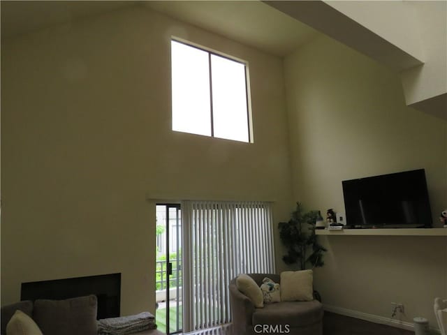 5744 E Creekside Ave Unit 10, Orange, CA 92869 - living area with healthy amount of natural light, a fireplace, baseboards, and a towering ceiling