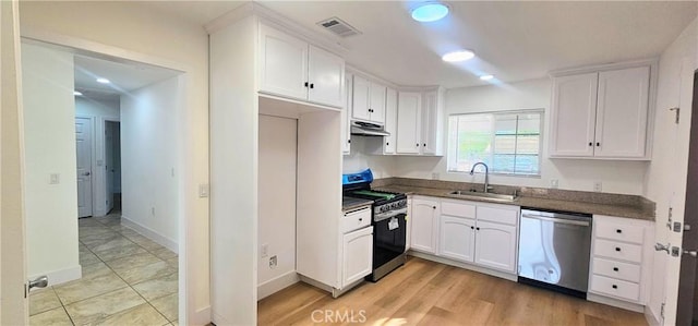 25687 Sandy Lodge Rd, Menifee, CA 92586 - kitchen with appliances with stainless steel finishes, a sink, dark countertops, under cabinet range hood, and white cabinetry