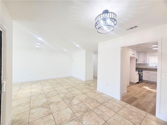 25687 Sandy Lodge Rd, Menifee, CA 92586 - unfurnished living room featuring a chandelier, a sink, baseboards, and light tile patterned floors