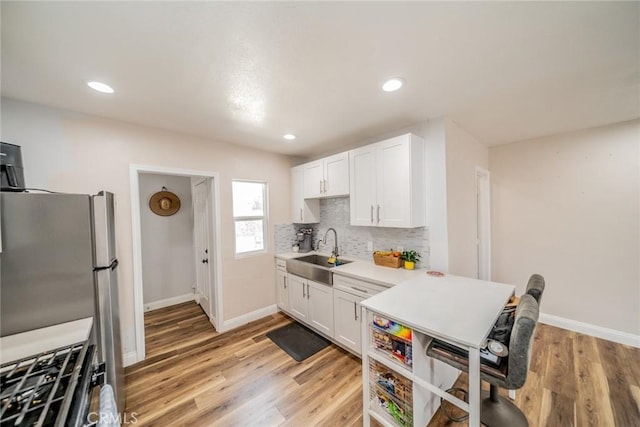 414 Iowa Ave, Riverside, CA 92507 - kitchen with white cabinets, light countertops, tasteful backsplash, light wood-type flooring, and gas range