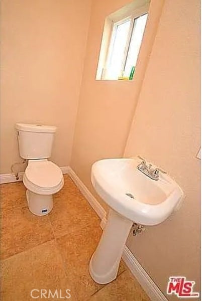 5102 Woodlawn Ave, Los Angeles, CA 90011 - half bath with toilet and tile patterned flooring