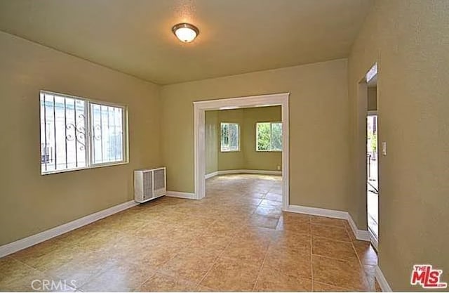 5102 Woodlawn Ave, Los Angeles, CA 90011 - unfurnished room with radiator and tile patterned flooring