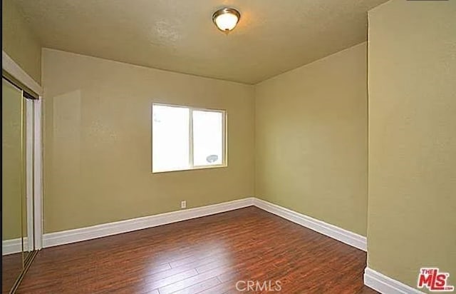 5102 Woodlawn Ave, Los Angeles, CA 90011 - spare room featuring dark wood-style flooring and baseboards