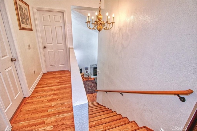 27126 Majello Ct, Temecula, CA 92591 - staircase with wood finished floors, a chandelier, and a textured wall