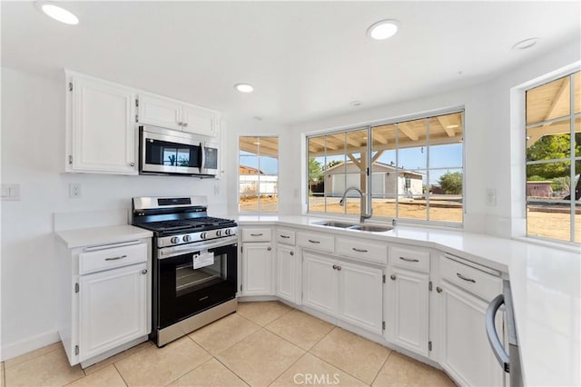 18346 Hackberry St, Hesperia, CA 92345 - kitchen with stainless steel appliances, a sink, white cabinetry, light tile patterned floors, and light countertops