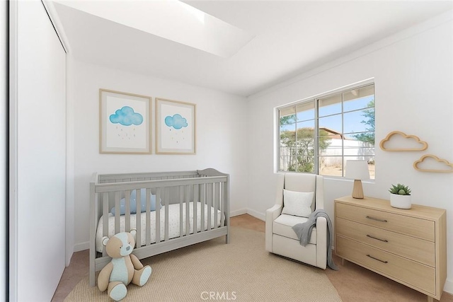 18346 Hackberry St, Hesperia, CA 92345 - bedroom with light carpet, a crib, a skylight, and baseboards