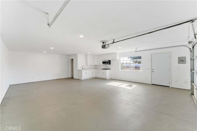 18346 Hackberry St, Hesperia, CA 92345 - garage with a garage door opener, a sink, recessed lighting, and electric panel