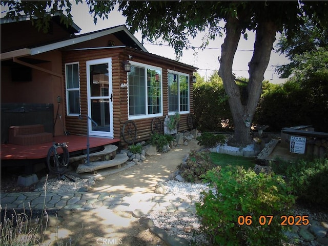 635 5th St, Willows, CA 95988 - view of property exterior with a hot tub, a wooden deck, and faux log siding