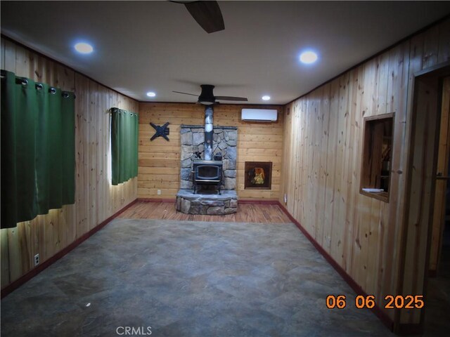 635 5th St, Willows, CA 95988 - basement with ceiling fan, a wood stove, wooden walls, recessed lighting, and a wall mounted air conditioner