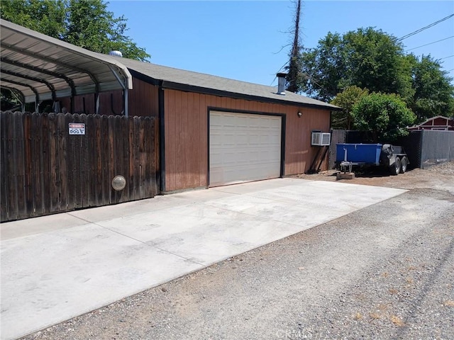 635 5th St, Willows, CA 95988 - garage featuring an AC wall unit and concrete driveway