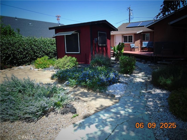 635 5th St, Willows, CA 95988 - view of front of house with solar panels, a wooden deck, and an outdoor structure