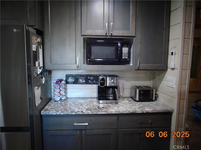 635 5th St, Willows, CA 95988 - kitchen with freestanding refrigerator, black microwave, and light stone countertops