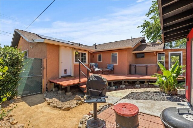 635 5th St, Willows, CA 95988 - back of house featuring a hot tub, stucco siding, a deck, and a patio area
