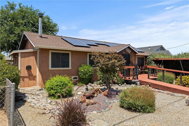 635 5th St, Willows, CA 95988 - ranch-style home with stucco siding, solar panels, a shingled roof, and a wooden deck