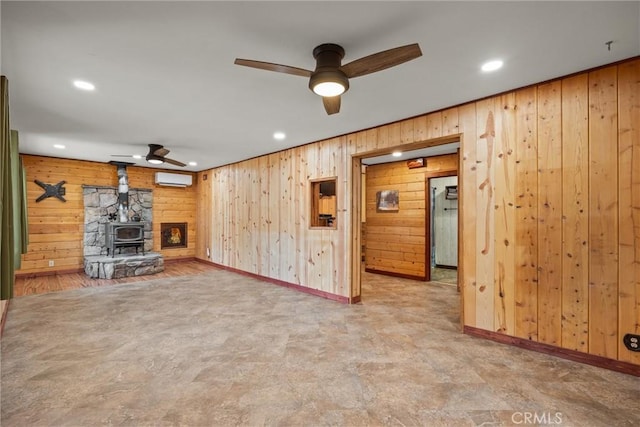 635 5th St, Willows, CA 95988 - unfurnished living room with wood walls, ceiling fan, a wood stove, a wall mounted air conditioner, and recessed lighting