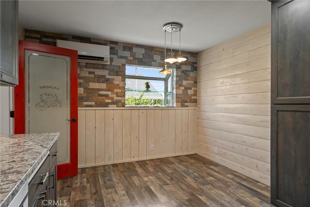 635 5th St, Willows, CA 95988 - unfurnished dining area with an AC wall unit, wooden walls, and dark wood-style floors