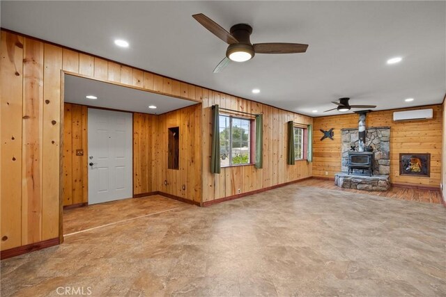 635 5th St, Willows, CA 95988 - unfurnished living room with wood walls, a ceiling fan, a wall mounted AC, a wood stove, and recessed lighting