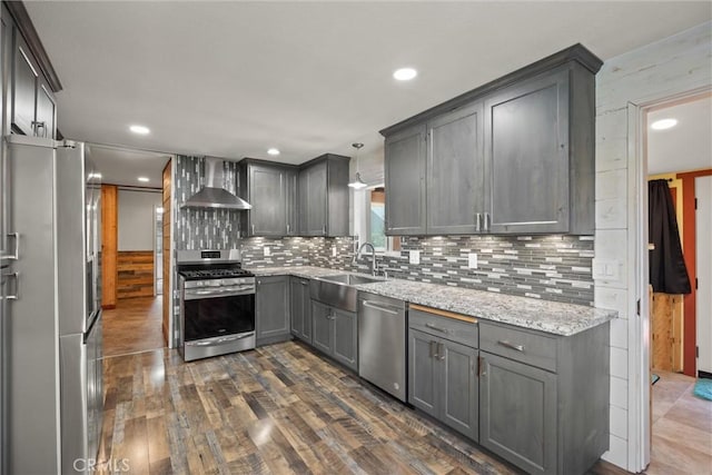 635 5th St, Willows, CA 95988 - kitchen with appliances with stainless steel finishes, wall chimney exhaust hood, gray cabinetry, backsplash, and dark wood-style floors