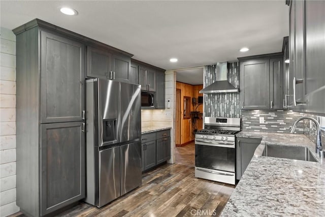 635 5th St, Willows, CA 95988 - kitchen featuring appliances with stainless steel finishes, wall chimney exhaust hood, light stone countertops, dark wood-type flooring, and decorative backsplash