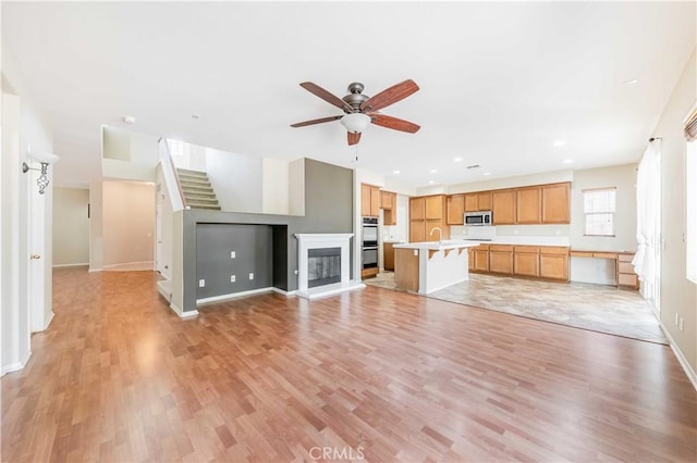 37245 La Lune Ave, Murrieta, CA 92563 - unfurnished living room with a ceiling fan, light wood-type flooring, baseboards, recessed lighting, and stairs