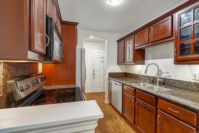 4570 54th St Unit 208, San Diego, CA 92115 - kitchen featuring stainless steel appliances, a sink, arched walkways, glass insert cabinets, and light wood-type flooring