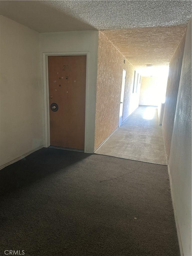 5429 Newcastle Ave Unit 206, Encino, CA 91316 - corridor featuring carpet flooring, a textured ceiling, and a textured wall