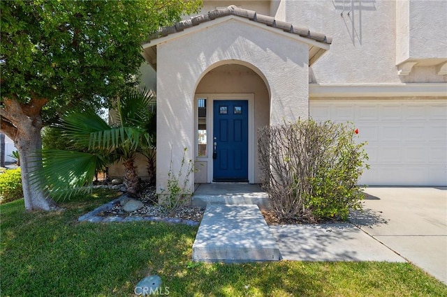 32702 Willowvail Cir, Temecula, CA 92592 - view of exterior entry with stucco siding, an attached garage, and driveway