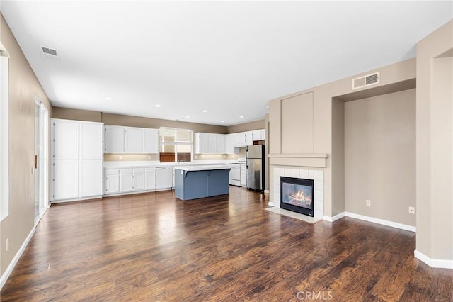 32702 Willowvail Cir, Temecula, CA 92592 - unfurnished living room with baseboards, dark wood-style floors, a tiled fireplace, and recessed lighting