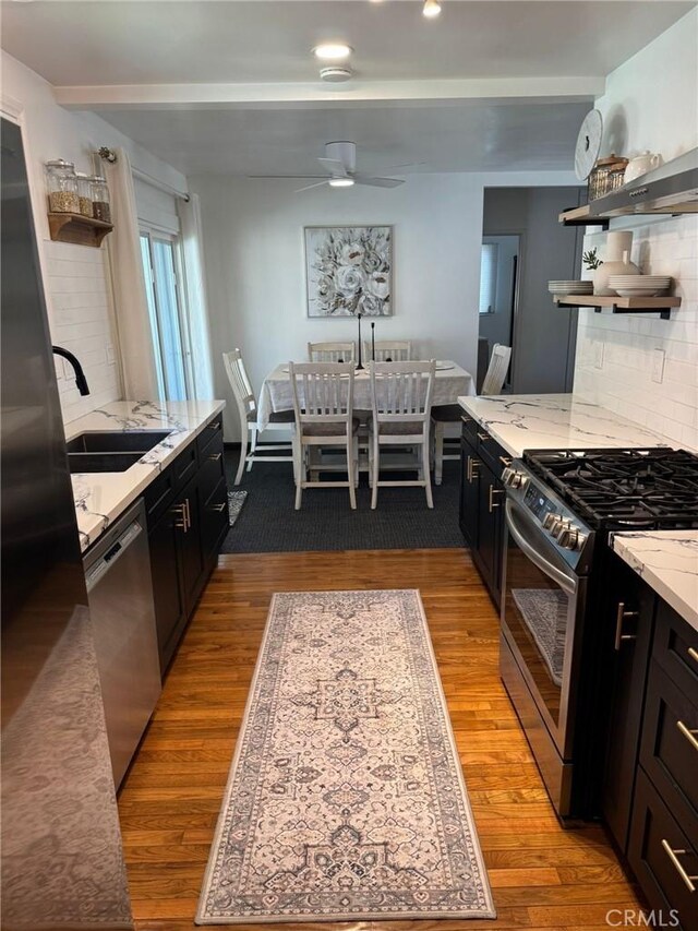 7548 Kilgarry Ave, Pico Rivera, CA 90660 - kitchen featuring stainless steel appliances, a sink, open shelves, light stone counters, and decorative backsplash