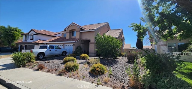 12609 Gentle Breeze Way, Victorville, CA 92392 - mediterranean / spanish home with stucco siding, a garage, a tiled roof, and driveway