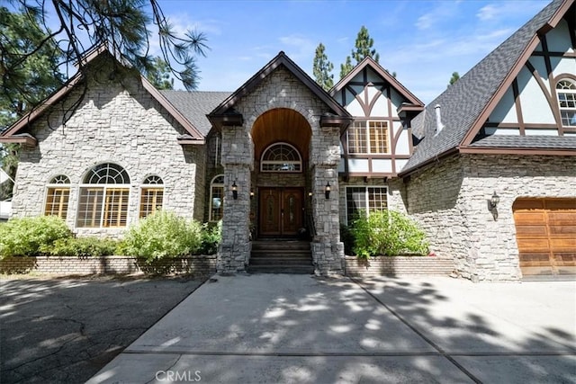 114 Starvation Flats Rd, Big Bear Lake, CA 92315 - view of front of house featuring stone siding, roof with shingles, a garage, and concrete driveway